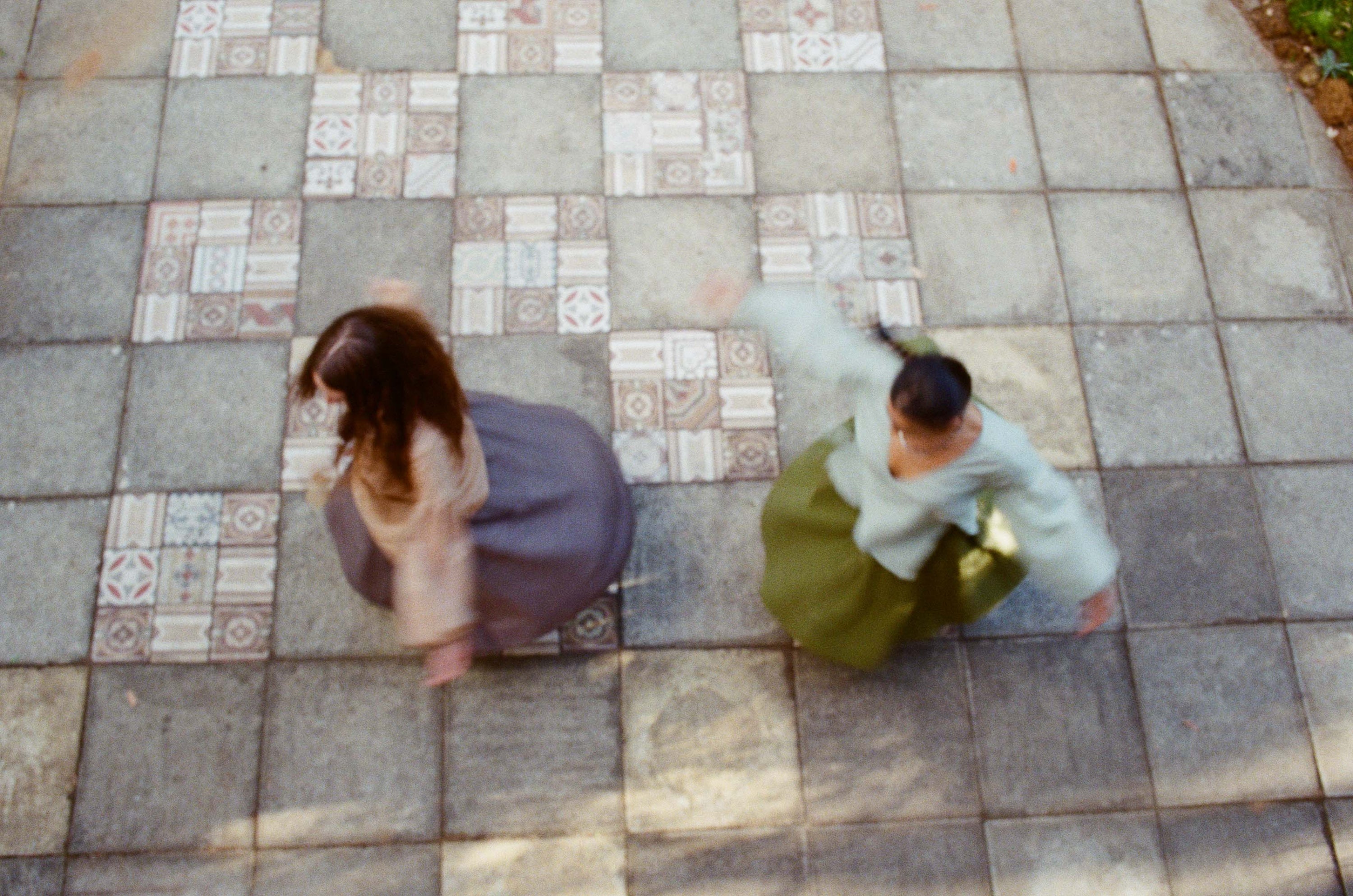 Two people spinning with arms out in motion, wearing the Leni blouse and the Manisha skirt.