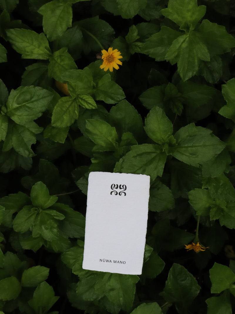 White card with text and numbers on a background of green leaves and small yellow flowers